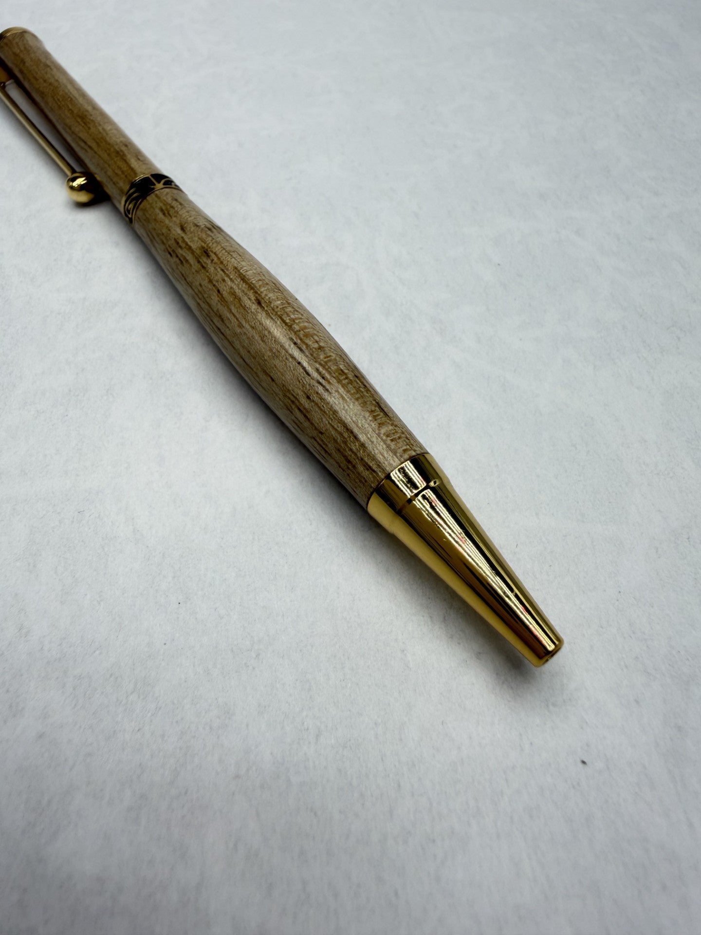 Détail pointe plaquée or 24k du stylo en bois Noyer – finition Aussi Oil, brillance éclatante